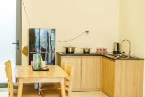 a kitchen with a wooden table and a refrigerator at Libra House Phu Quoc in Phú Quốc