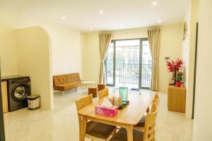 a living room with a wooden table and a dining room at Libra House Phu Quoc in Phú Quốc