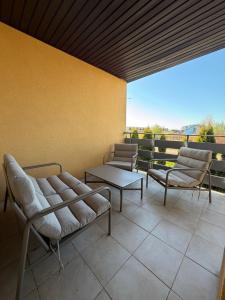 a patio with two chairs and a table on a balcony at Apartament Wczasowa 3 in Sarbinowo