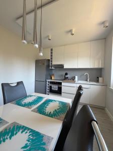a kitchen with a table and chairs in a room at Apartament Wczasowa 3 in Sarbinowo