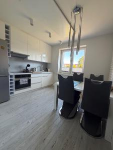 a kitchen with a table and chairs in a room at Apartament Wczasowa 3 in Sarbinowo +5 photos