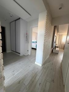 an empty room with a white brick wall and wooden floors at Apartament Wczasowa 3 in Sarbinowo