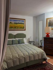 a bedroom with a bed and a painting on the wall at CASA DI ALICE a Sambuca Val di Pesa in Badia A Passignano