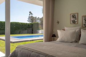 a bedroom with a bed and a view of a pool at Marianas in Bom Sucesso +49 photos