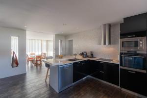 a kitchen with black and white appliances and a table at Marianas in Bom Sucesso