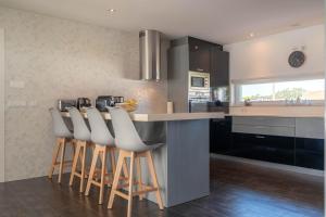 a kitchen with a counter and a bar with stools at Marianas in Bom Sucesso
