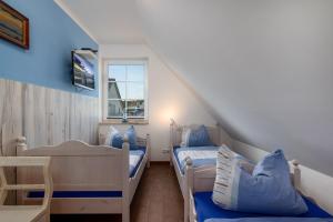 a attic room with two beds and a window at Strandhaus zum Lotsenturm in Thiessow
