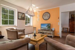 a living room with a table and a tv at Strandhaus zum Lotsenturm in Thiessow