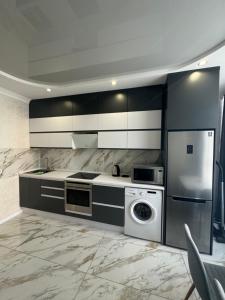 a kitchen with a stove and a washer and dryer at ЖК Акварель 2 in Odesa