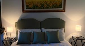 a bedroom with a bed with two lamps and a painting at CASA DI ALICE a Sambuca Val di Pesa in Badia A Passignano