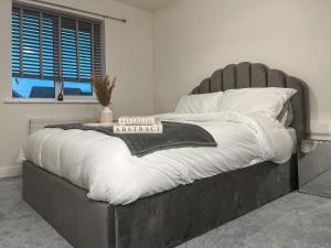 a bed with a black and white comforter and pillows at Spring Gardens in Lower Darwen