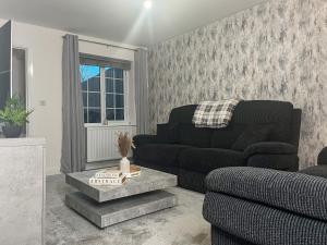 a living room with a couch and a chair at Spring Gardens in Lower Darwen