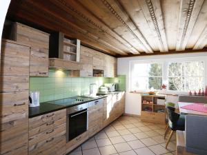 a kitchen with wooden cabinets and green tiles at Vacation home in Flachau in Flachau