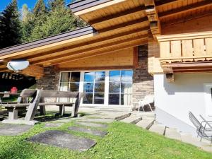 a patio with a bench under a wooden roof at Vacation home in Flachau in Flachau +10 photos