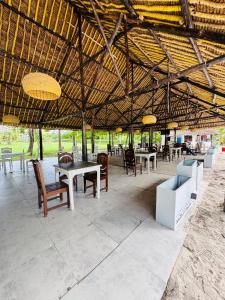 a pavilion with tables and chairs under a roof at Bahari Studio Beach Front Apartment. in Diani Beach