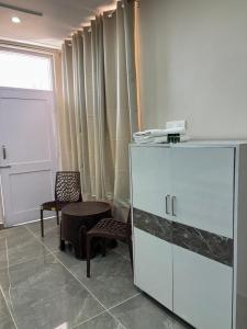 a room with a cabinet and two chairs and a window at ZuZu Hostels Mcleodganj in Dharamshala