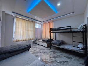 a bedroom with two bunk beds and a blue ceiling at ZuZu Hostels Mcleodganj in Dharamshala