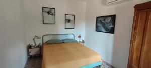 a bed in a room with three pictures on the wall at B&B Casa Fattorini in Cortona