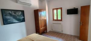 a bedroom with a bed and a window and a door at B&B Casa Fattorini in Cortona