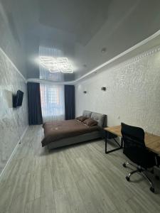 a bedroom with a bed and a desk in it at ЖК Акварель 2 in Odesa