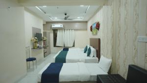 a hotel room with two beds and a television at Hotel Lord Krishna Dham in Dwarka +51 photos
