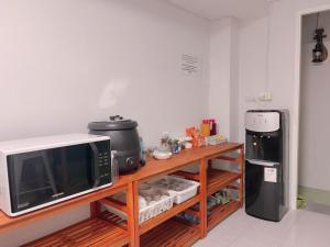 a kitchen with a microwave and a refrigerator at latitude 14 Room & breakfast in Ban Bang Sakae
