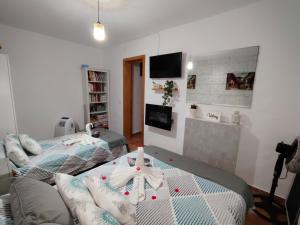 a bedroom with two beds and a tv at LAS TRES ROSAS in Vejer de la Frontera +40 photos