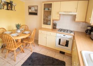 a kitchen with a table and chairs and a stove at 2 Bed Semi - Sleeps 4 - Fully Fenced Garden & Parking - Quiet Cul De Sac Location - Dog Friendly - Fast Wifi - Close to Motorway Access in Doncaster