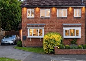 a red brick house with a car parked in the driveway at 2 Bed Semi - Sleeps 4 - Fully Fenced Garden & Parking - Quiet Cul De Sac Location - Dog Friendly - Fast Wifi - Close to Motorway Access in Doncaster