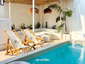 a group of chairs sitting next to a swimming pool at White Villa in General Santos