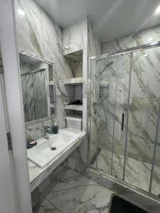 a bathroom with a sink and a shower at ЖК Акварель 2 in Odesa +7 photos