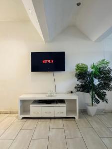 a living room with a tv on a wall at Bahari Studio Beach Front Apartment. in Diani Beach