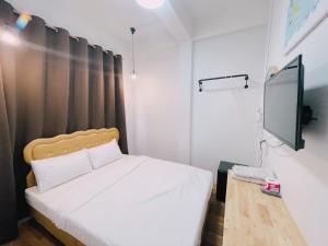 a bedroom with a bed and a flat screen tv at latitude 14 Room & breakfast in Ban Bang Sakae