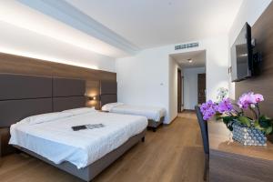 a hotel room with two beds and a television at Park Hotel Gemona in Gemona del Friuli