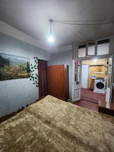 a bedroom with a large bed and a kitchen at Live as you are LOCAL in Tbilisi City