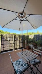 a patio with a white umbrella and two chairs at CASA DI ALICE a Sambuca Val di Pesa in Badia A Passignano +12 photos