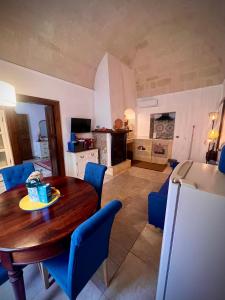 a kitchen and dining room with a wooden table and blue chairs at Le Dimore al Castello in Massafra
