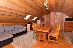 a dining room with a wooden table and a couch at Svajonių Dvaras in Balninkai