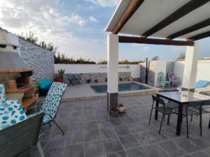 a patio with a table and chairs and a swimming pool at La magia del sur 2 in Cádiz