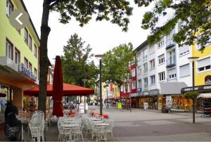 a city street with tables and chairs and buildings at Wohnung am Rosengarten in Kehl am Rhein