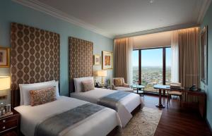 a hotel room with two beds and a large window at The Leela Gandhinagar in Gandhinagar +31 photos