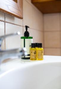 two bottles of soap sitting on a bathroom sink at Alexis new villas in Chrysi Ammoudia +34 photos
