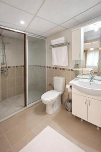 a bathroom with a toilet and a shower and a sink at Coskun Otel Şarköy in Şarköy