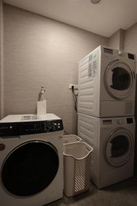 a laundry room with a washer and a washing machine at Fun Stay Inn Hanzhong in Taipei