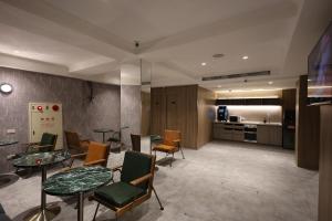 a living room with tables and chairs and a kitchen at Fun Stay Inn Hanzhong in Taipei