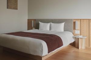 a bedroom with a large bed and a table at TOMI Ginza in Tokyo