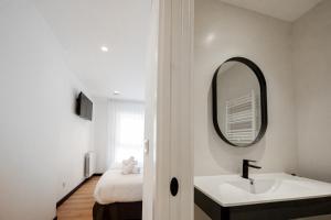 a bathroom with a sink and a mirror at Donosti rooms in Loyola
