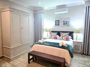 a bedroom with a large bed and a cabinet at 2 Owls Guesthouse in Potchefstroom
