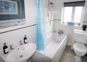 a bathroom with a toilet and a tub and a sink at 2 Bed House - Sleeps 4 - Parking - Pets - Garden in Doncaster +30 photos