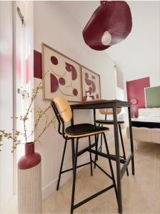 a room with a desk and a chair and a bedroom at La Suite Bohème Émeraude in Évreux